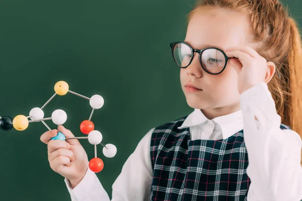 Beautiful Little Schoolgirl Eyeglasses Holding Molecular Model While Standing Chalkboard — Stock Photo, Image