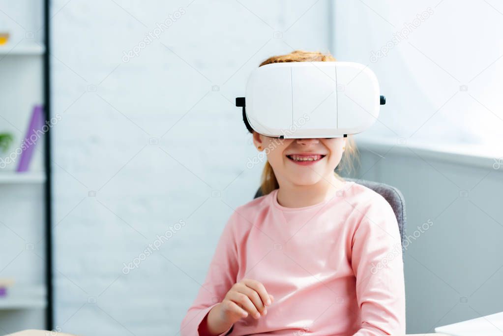 beautiful smiling redhead kid using virtual reality headset at home