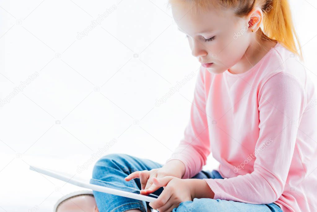 cropped shot of beautiful redhead kid using digital tablet