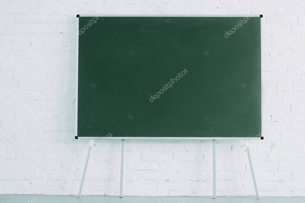 blank blackboard and white brick wall