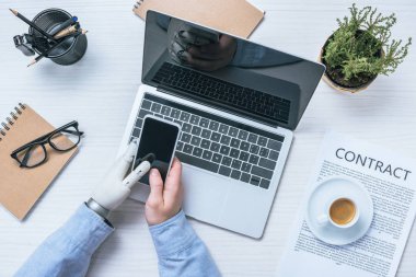Protez kol smartphone masada dizüstü Office ile kontrol ile işadamı resim kırpılmış 