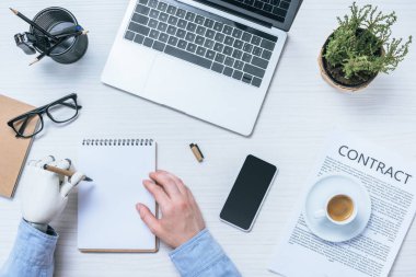 Protez kol sözleşme kağıtları ve office gadget'lar ile masada ders kitabı yazma ile işadamı resim kırpılmış 