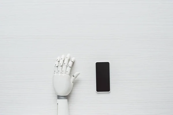 Avskårne Bilder Protese Arm Smarttelefon Med Blank Skjerm Ved Trebord – stockfoto