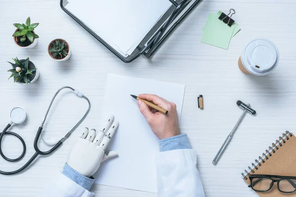 Imagen Recortada Médico Varón Con Prótesis Brazo Escritura Papel Blanco — Foto de Stock