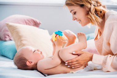 mutlu anne o oyuncakla oynamak ise küçük çocuk bezi koyarak