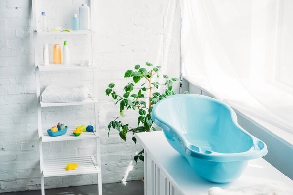 пластиковая ванна для детей на стенде в белом современном номере
