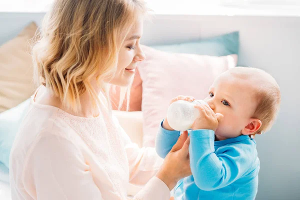 Mãe Feliz Alimentando Seu Filho Com Mamadeira Casa — Fotografia de Stock