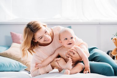 mutlu anne ve çocuk evde yatakta rahatlatıcı