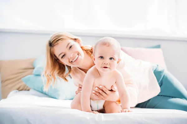 Moeder Haar Kindje Terwijl Hij Kruipen Bed Thuis Ondersteuning — Stockfoto