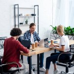 Zespół młodych biznesowych za pomocą laptopów siedząc razem w miejscu pracy