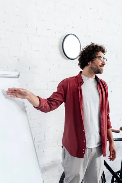 Joven Con Gafas Apuntando Pizarra Blanca Mirando Hacia Otro Lado — Foto de stock gratis