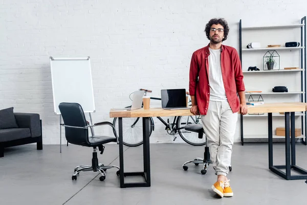 Vista Completa Hombre Joven Guapo Gafas Inclinadas Mesa Mirando Cámara — Foto de Stock