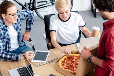 gençlerin birlikte çalışırken pizza yemek yüksek açılı görünüş