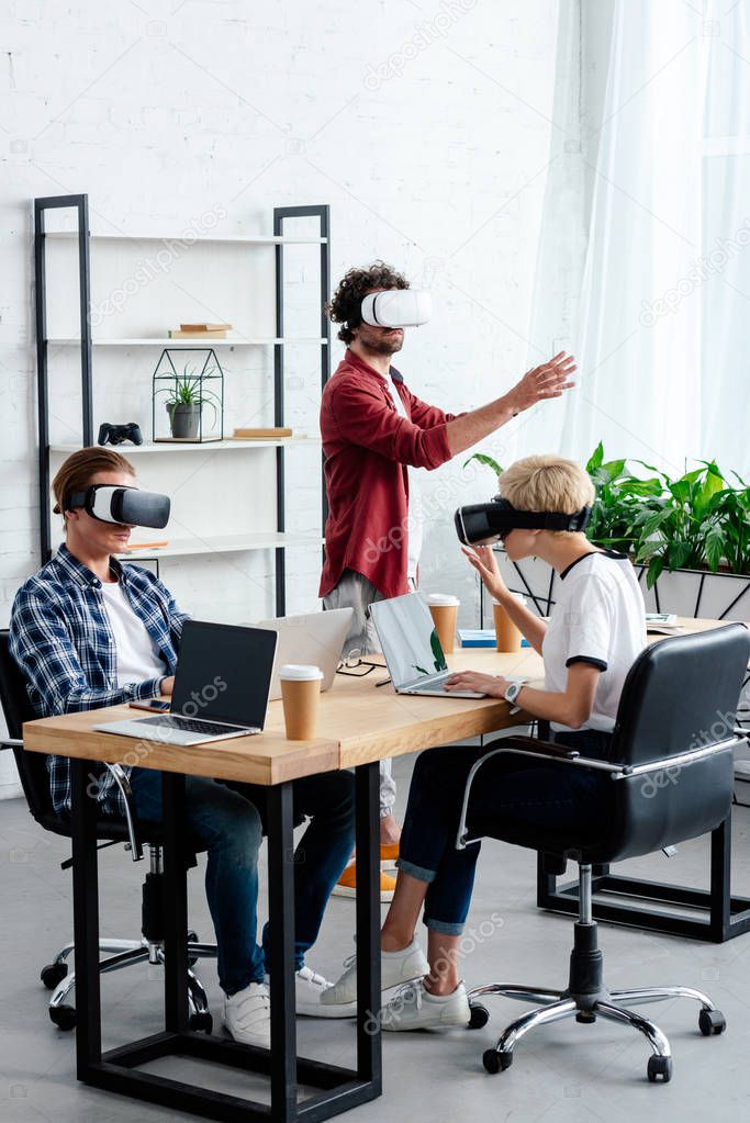 Young people using virtual reality headsets while working together