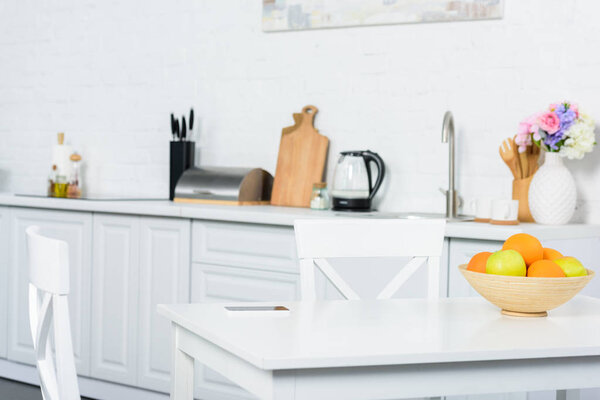 oranges and apples on white table in kitchen