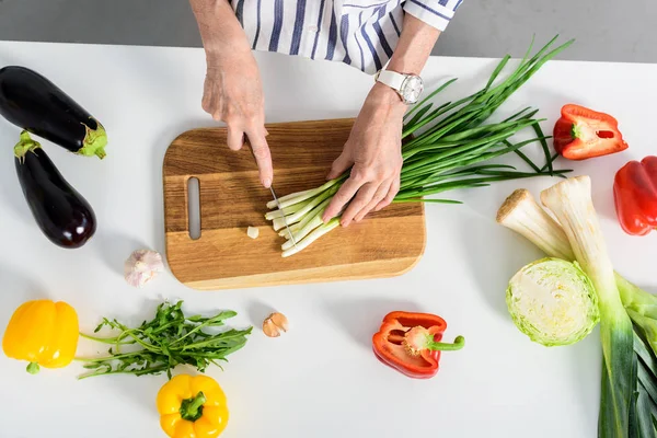 Image Recadrée Femme Âgée Coupant Oignon Vert Dans Cuisine — Photo