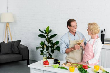 mutlu üst düzey çift bardak beyaz şarap ile mutfak yemek sırasında sorun