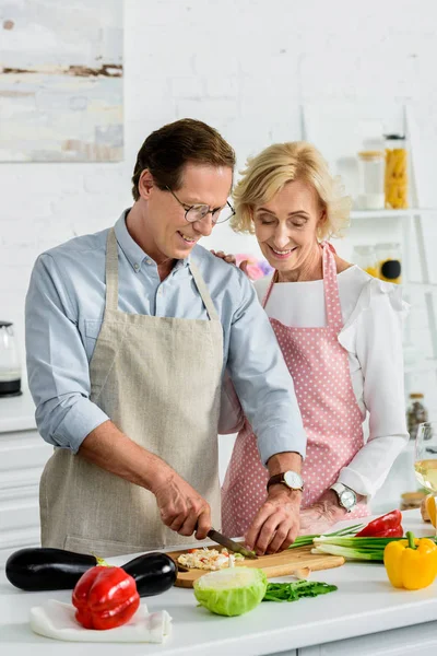 Glückliche Ältere Frau Umarmt Ehemann Während Grüne Zwiebeln Der Küche — Stockfoto