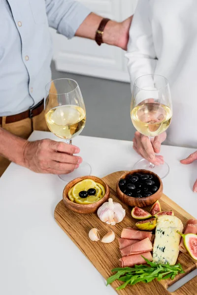 üst düzey iki bardak şarap lezzetli aperatifler evde tadını çıkarırken tutarak atış kırpılmış