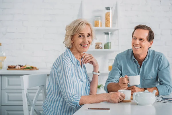 mutlu üst düzey çift birlikte evde çay içme