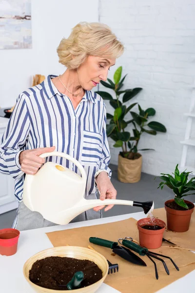 Beautiful Senior Woman Watering Soil Watering Can Home — Free Stock Photo