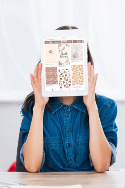 young woman covering face by digital tablet with pinterest website on screen  clipart