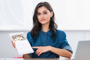 oturaklı Web sitesi ile dijital tablet ekranında işaret çekici genç kadın 