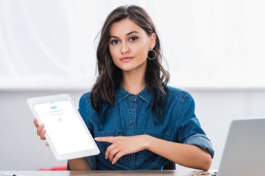 Dijital tablet ekranında skype uygulaması ile işaret çekici genç kadın 