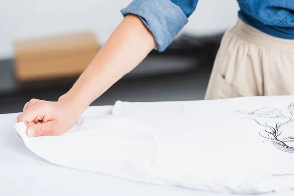 Imagen Recortada Del Diseñador Femenino Poniendo Camiseta Blanca Con Impresión — Foto de Stock