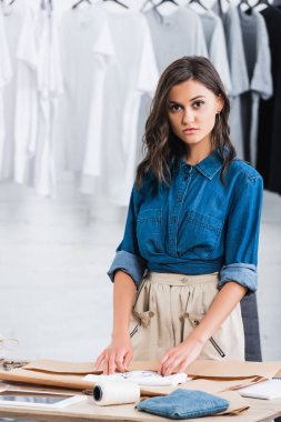 Genç kadın moda tasarımcısı t-shirt baskı masada kağıt pakette ile kaydırma 