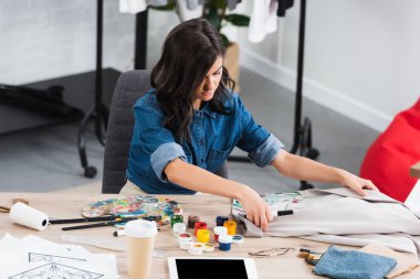kadın moda tasarımcısı masada kahve Kupası ve dijital tablet giyim tasarım Studio ile çalışma