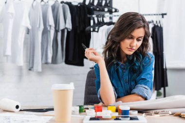 kadın moda tasarımcısı kahve fincanı giyim tasarım Studio ile çalışma masasında ceket boyama