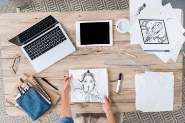 Beyaz t-shirt baskı ile dijital cihazlar bir resim sergisi ile masaya koyarak kadın Tasarımcısı kırpılmış görüntü 