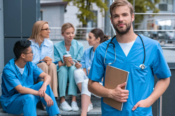 caucasian man standing in front of multiethnic teacher and students at medical university