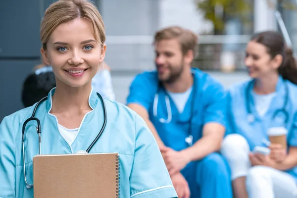 Usmívající Student Medicíny Stojí Poznámkový Blok Při Pohledu Fotoaparát — Stock fotografie