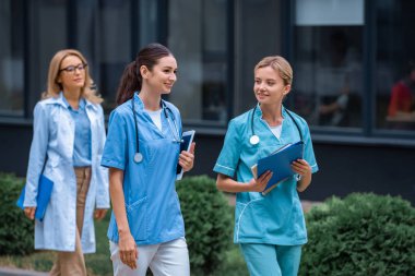 medical students and lecturer walking on street near university clipart