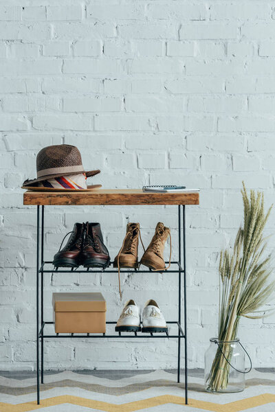 different shoes under wooden bench in corridor at home