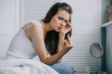parmak veren ve kamera yatak odasında bakarak baş ağrısı olan kadın