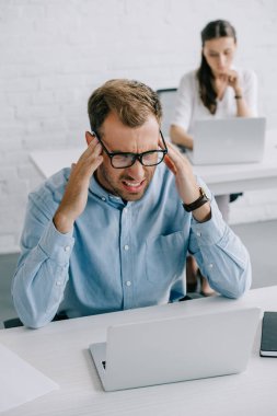 işadamı gözlük laptop Office ile çalışırken baş ağrısı acı içinde yüksek açılı görünüş