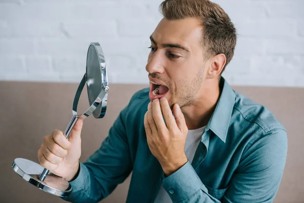 Jovem Com Dor Dente Olhando Para Espelho Enquanto Sentado Casa — Fotografia de Stock