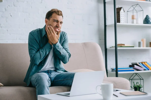 Young Man Suffering Toothache While Using Laptop Home — Stock Photo, Image