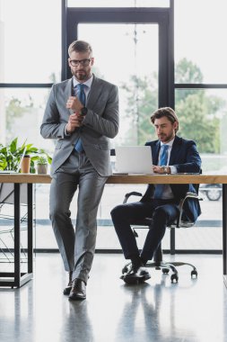 gözlük kamera arkasında dizüstü kullanarak meslektaşım süre bakarak yakışıklı genç işadamı