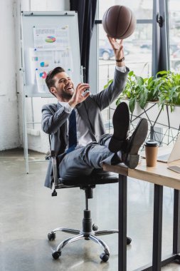 mutlu genç işadamı office üzerinde çalışırken ile basketbol top oynarken takım elbiseli