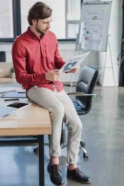 masada oturan ve ofiste iş gazete okuma yakışıklı genç işadamı