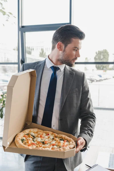 Красивый Молодой Бизнесмен Костюме Держит Коробку Пиццей Офисе — стоковое фото
