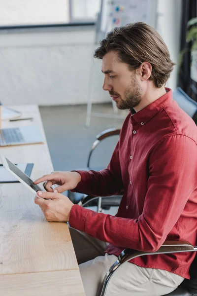 Vista Laterale Del Giovane Uomo Affari Seduto Utilizzando Tablet Digitale — Foto stock gratuita