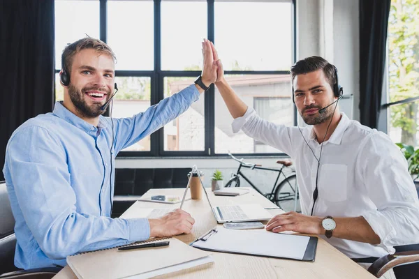 Jonge Call Center Exploitanten Hoofdtelefoons Geven Hoge Vijf Glimlachend Camera — Stockfoto