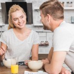 Casal tomando café da manhã na cozinha e olhando um para o outro