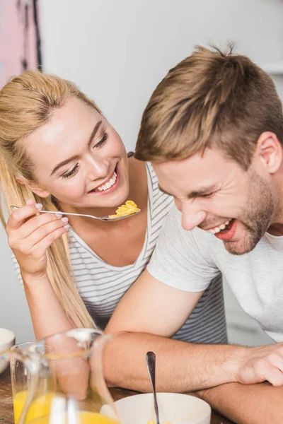 Leende Flickvän Utfodring Skrattande Pojkvän Med Cornflakes Kök — Gratis stockfoto