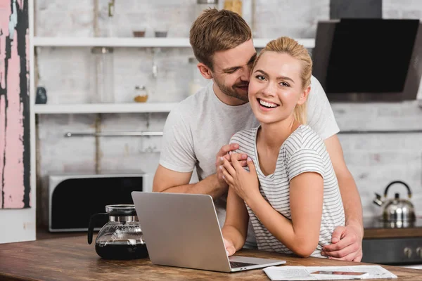 Boyfriend Hugging Laughing Girlfriend Kitchen While She Working Laptop — Stock Photo, Image
